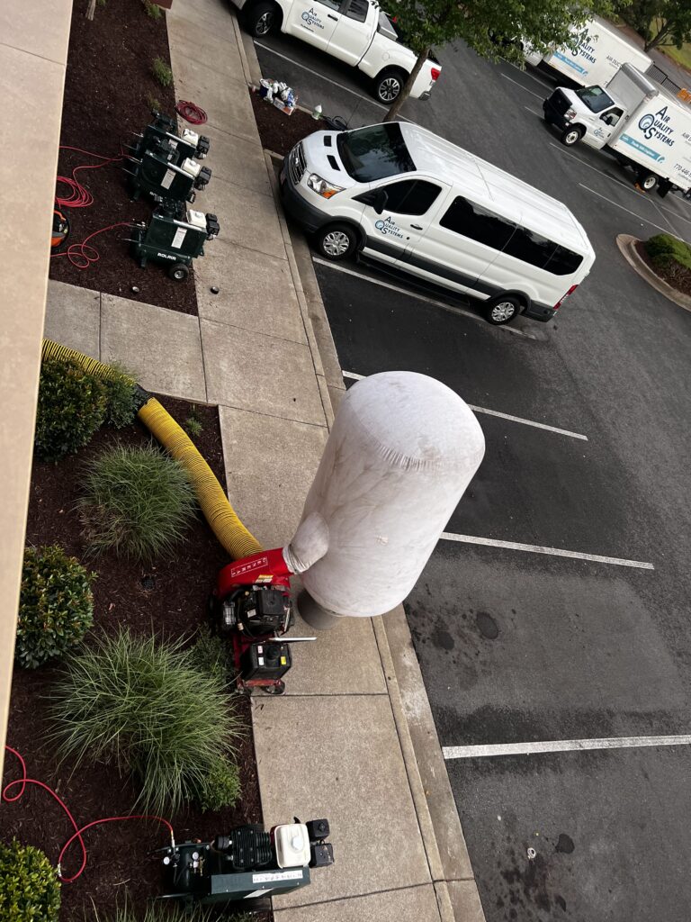 White air duct cleaning van and equipment on street, servicing commercial and residential buildings