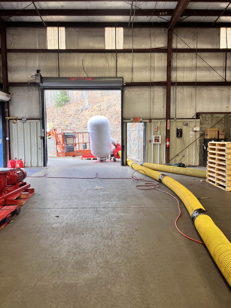 Industrial workspace with large air duct and cleaning equipment, ready for commercial duct cleaning services.