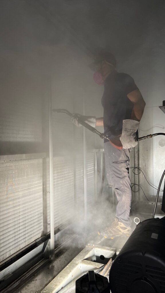 Technician cleaning commercial air ducts with specialized equipment, ensuring improved indoor air quality.
