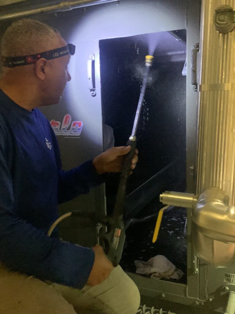 HVAC technician inspects residential furnace during duct cleaning service to improve air quality