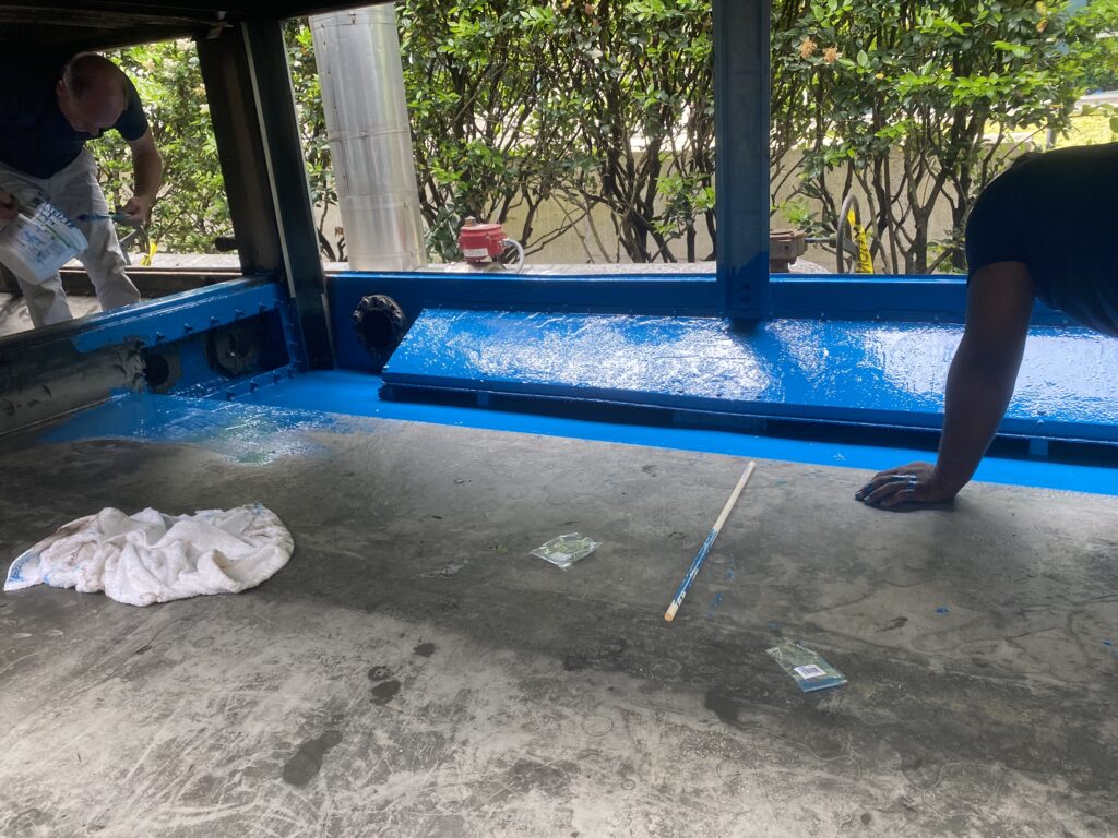 Workers cleaning commercial kitchen exhaust ductwork, removing built-up grease to improve airflow